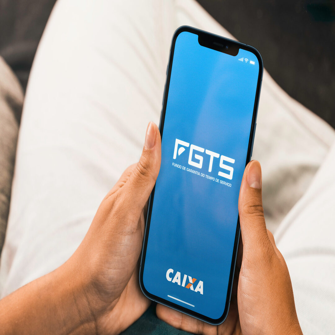 Female hand holding a smartphone with FGTS (Caixa) app on the screen. Brazilian worker guarantee fund. Rio de Janeiro, RJ, Brazil. October 2021.